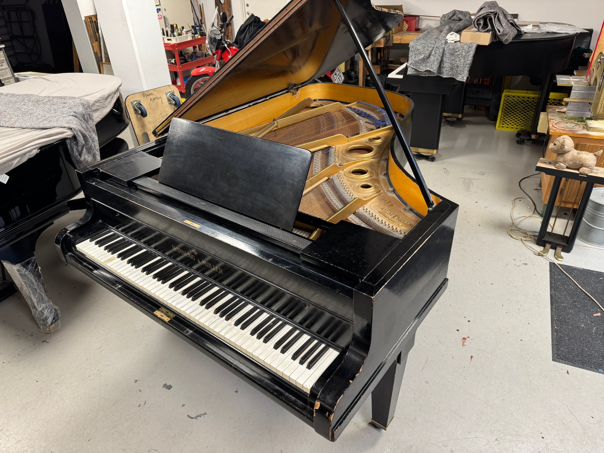 A black Hornung & Møller grand piano as found, lid open, before restoration