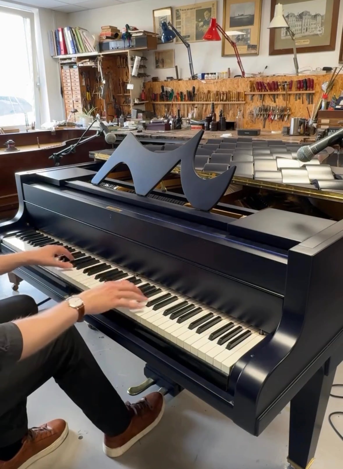A pianist playing the Wave piano, with its wave-shaped music desk